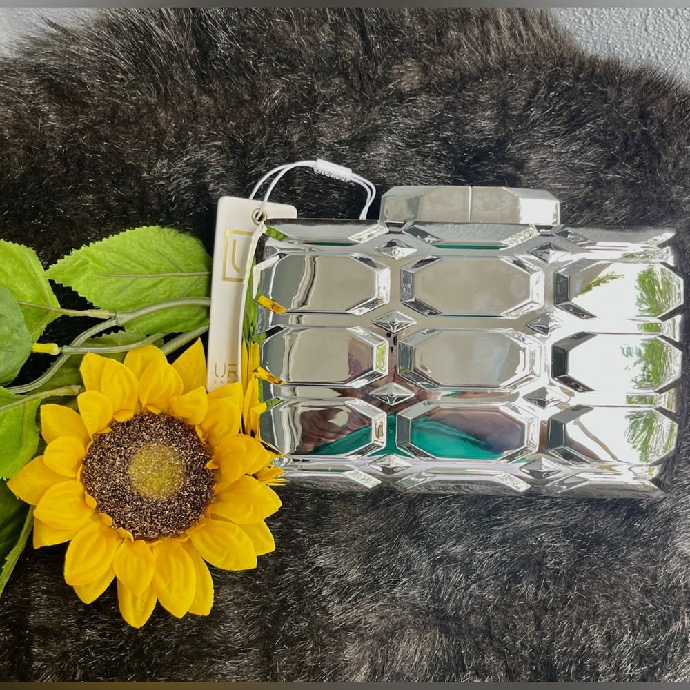 Unused,metallic silver 5x6 clutch with hard exterior. Includes silver strap too.